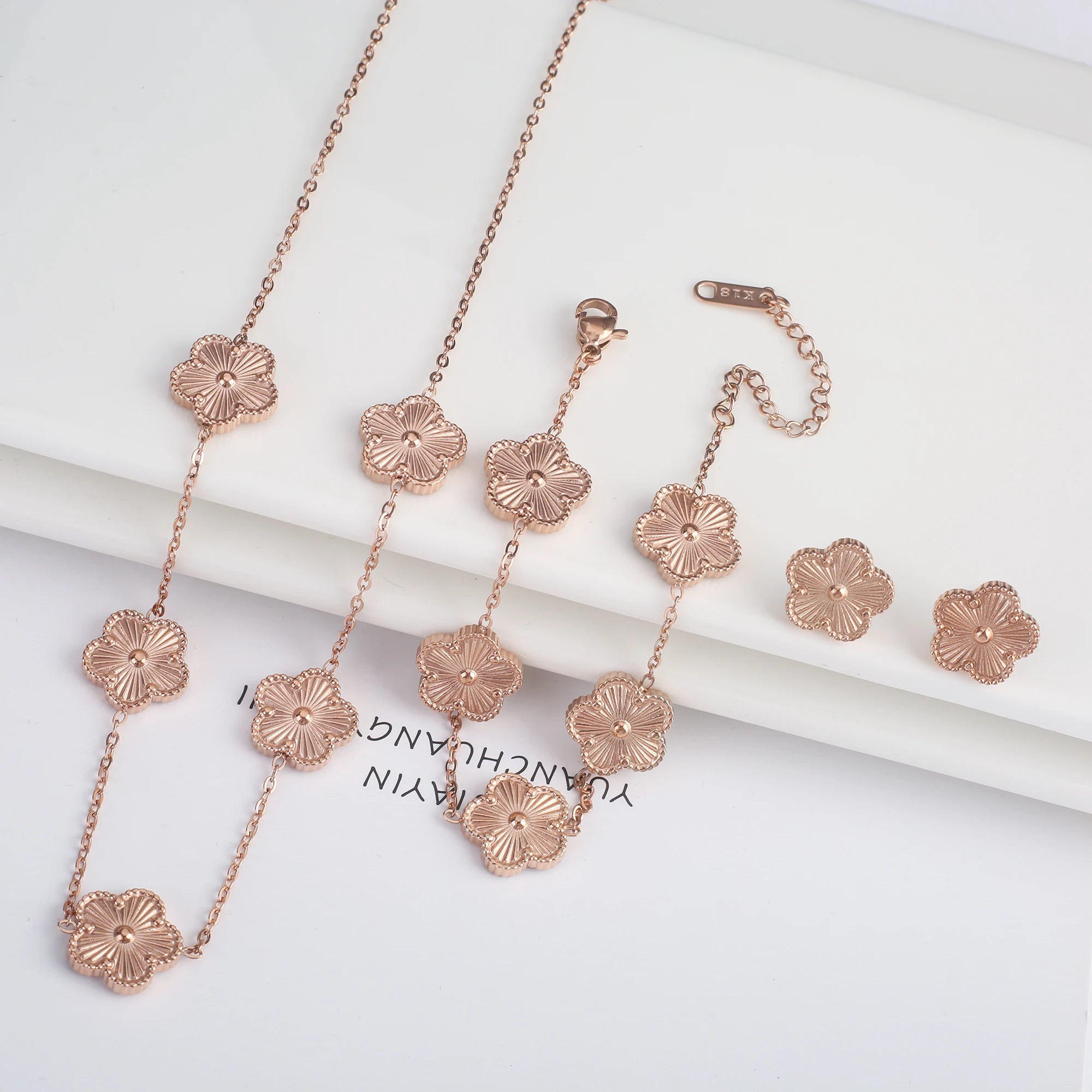 Three-piece clover jewelry set with five-leaf flower charms, rose gold tone necklaces and earrings