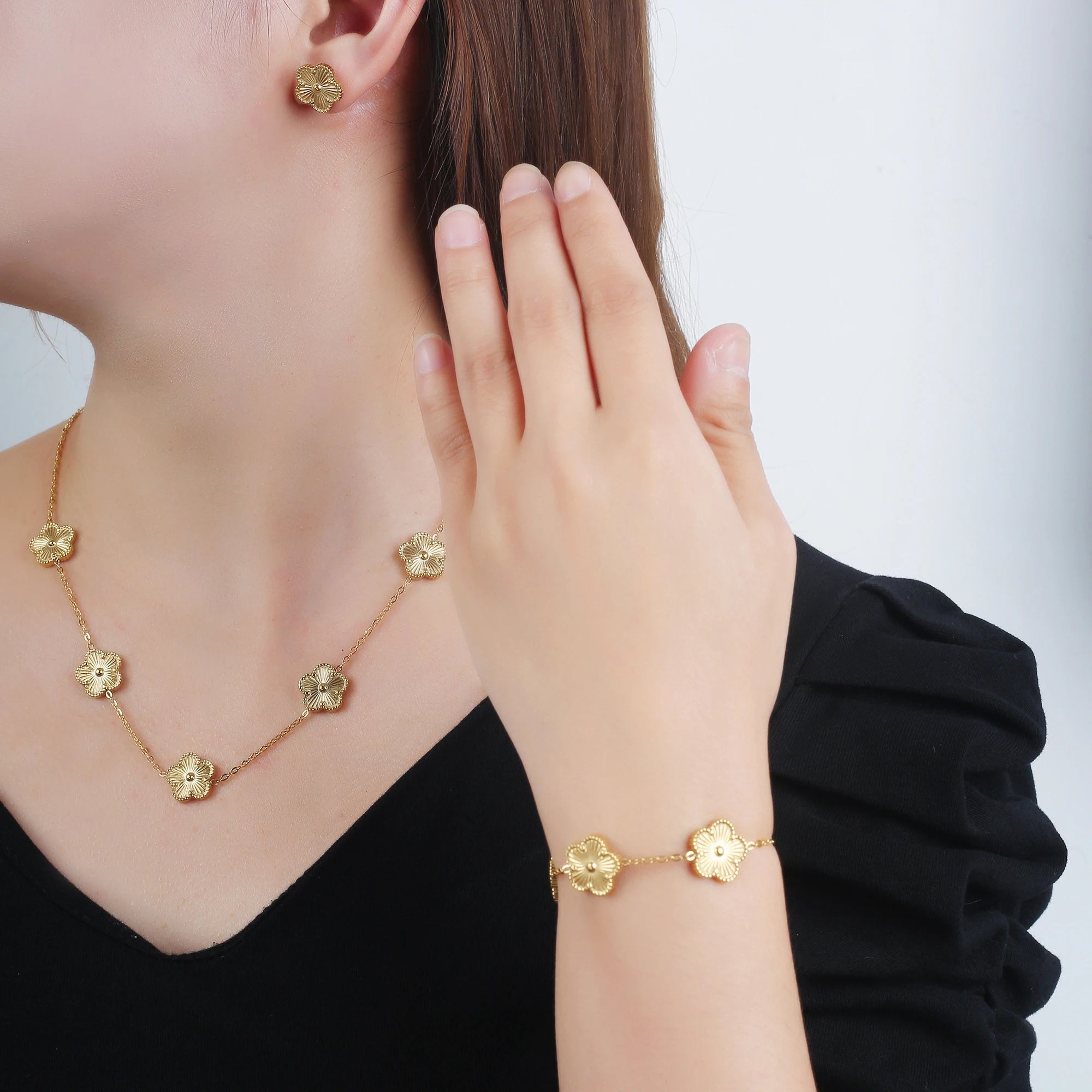 Gold-tone adjustable clover charm bracelet with small four-leaf enamel charms
