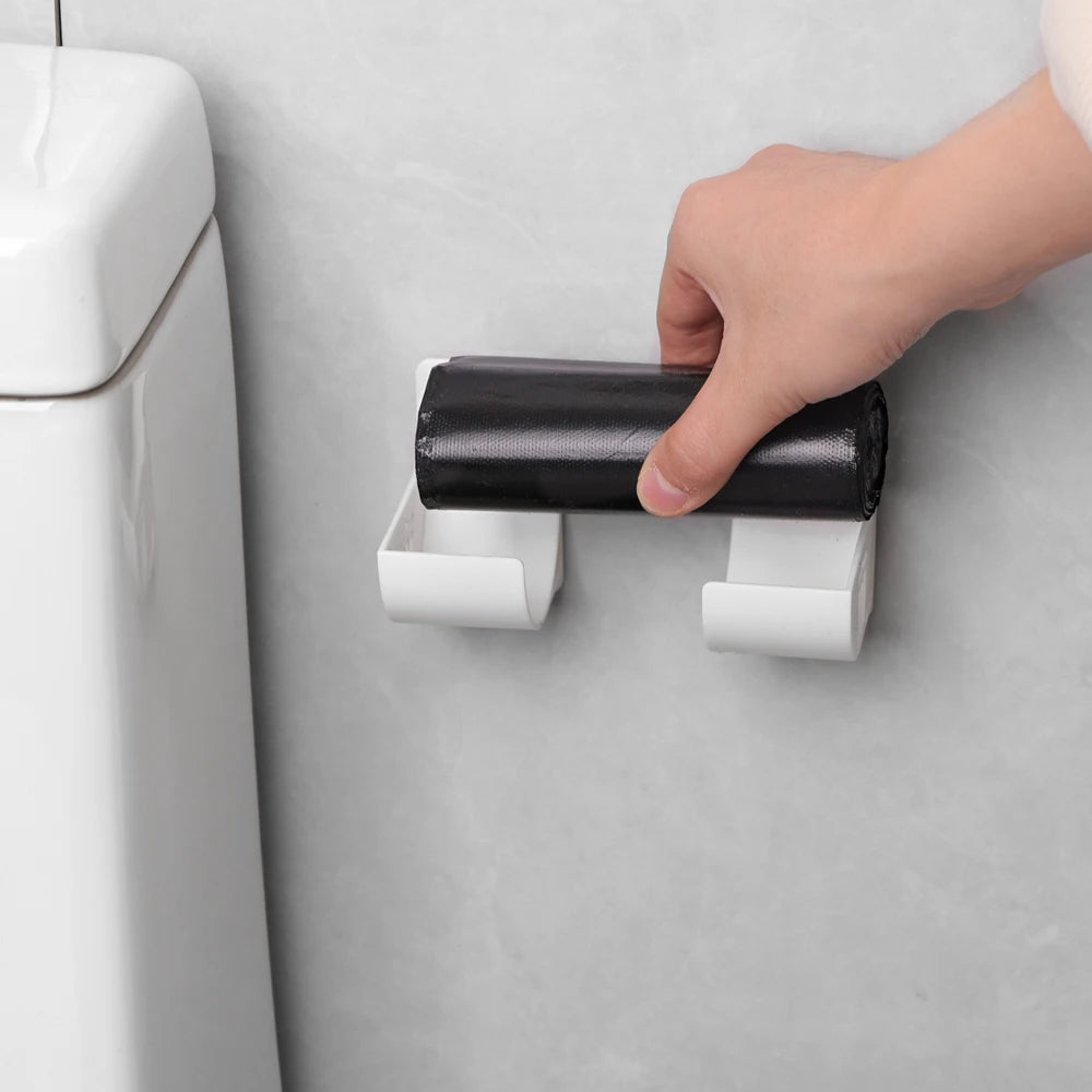 Wall-mounted trash bag holder with two white clips and a dark bag roll insert