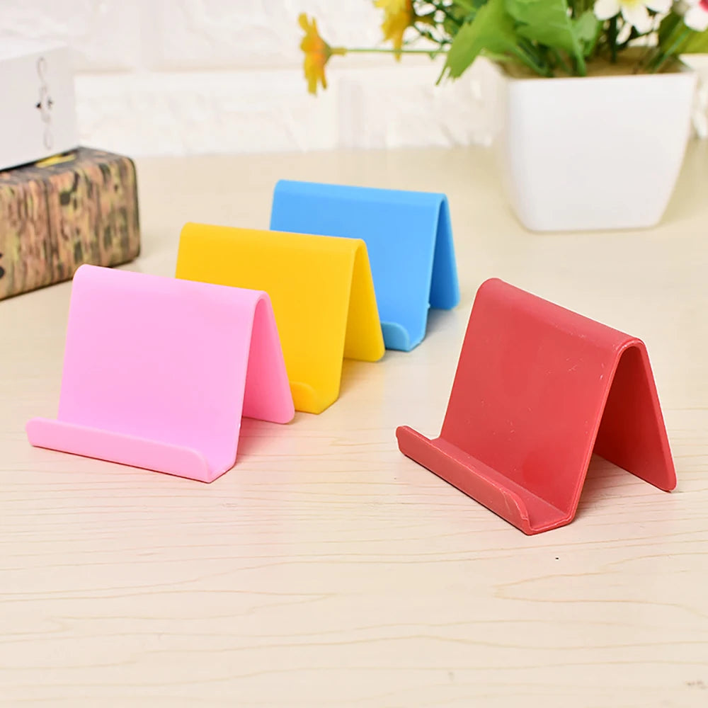 Assorted pastel plastic phone holder stands, foldable V-shape for desk use