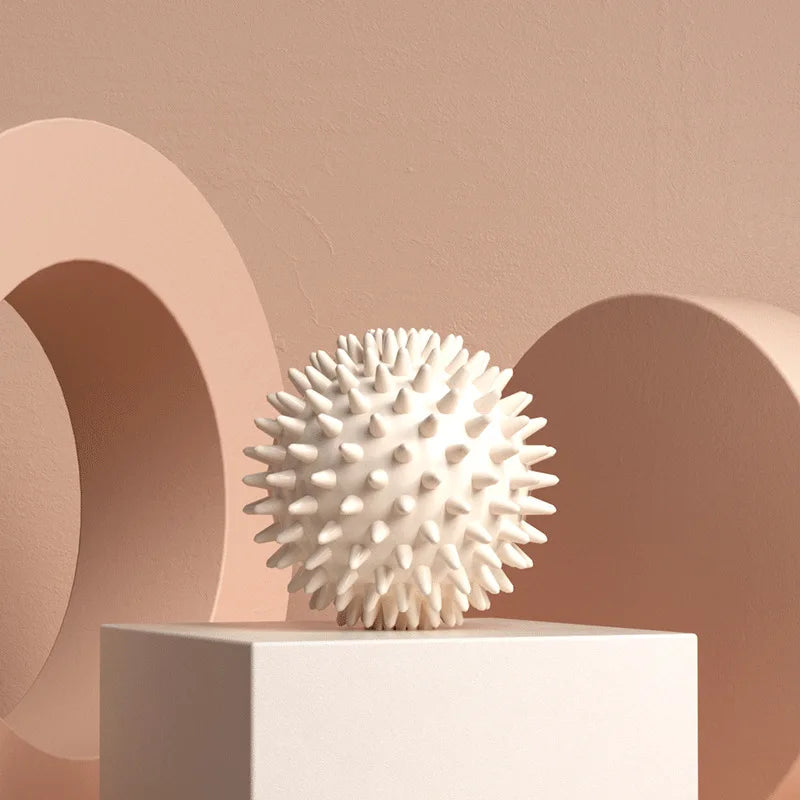 White spiky fascia massage ball on a pedestal
