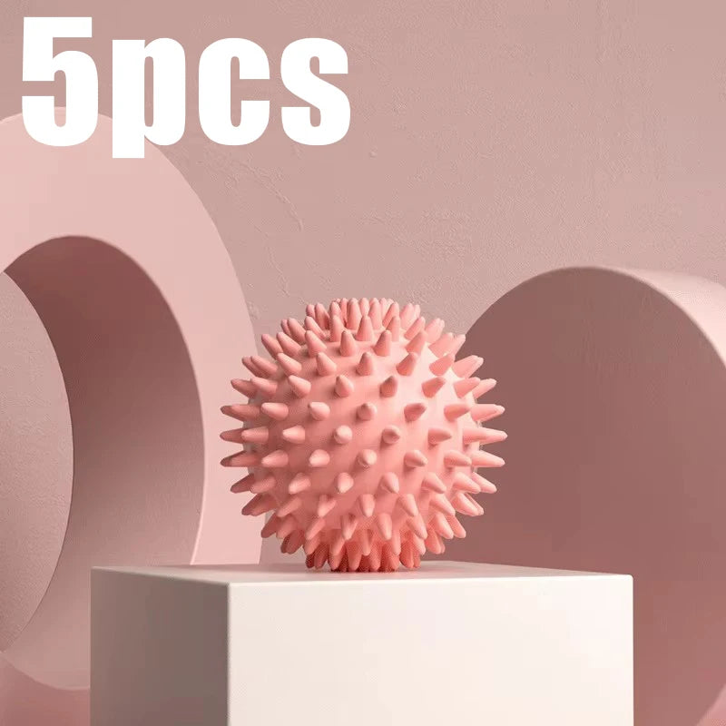 Pink spiky fascia massage ball for muscle relaxation, shown on a block pedestal