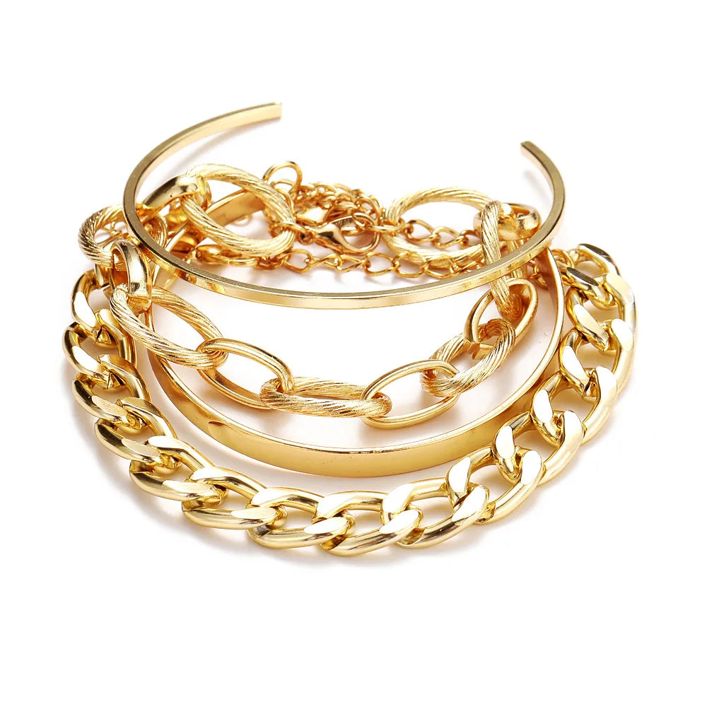 Gold-tone open bangle stack with curb link chains and shiny oval cuff