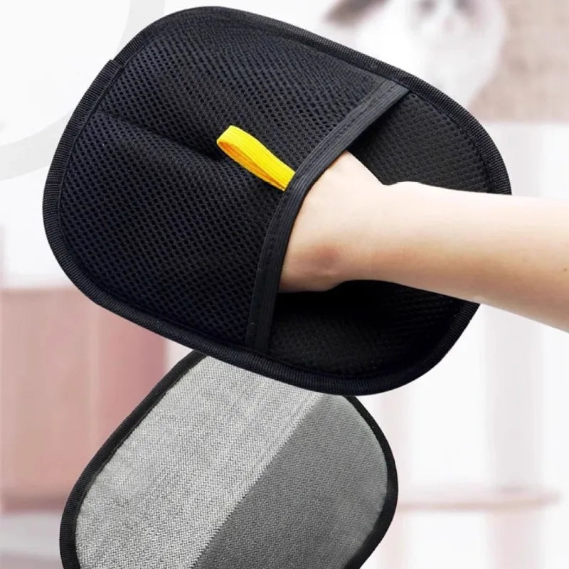 Double-sided pet grooming mitt held in hand, black mesh side with yellow tab