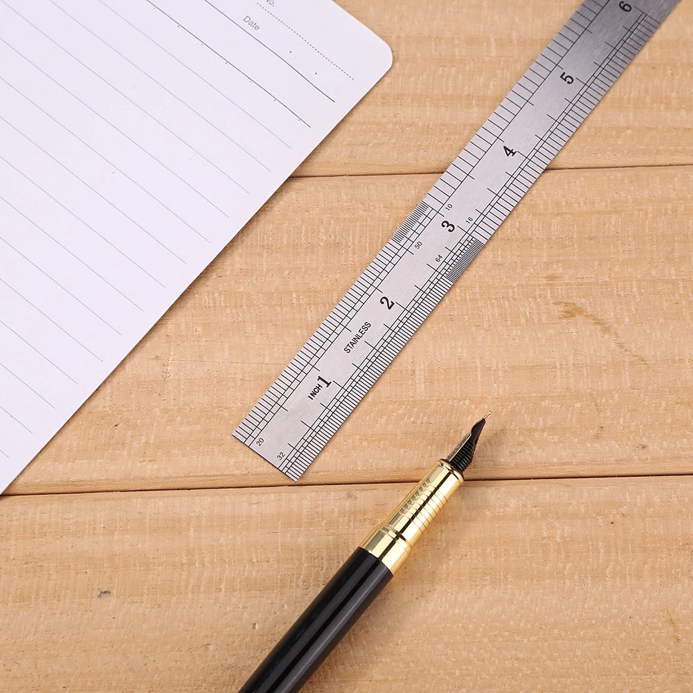 Stainless steel straight ruler on wooden surface with etched cm scale and pencil