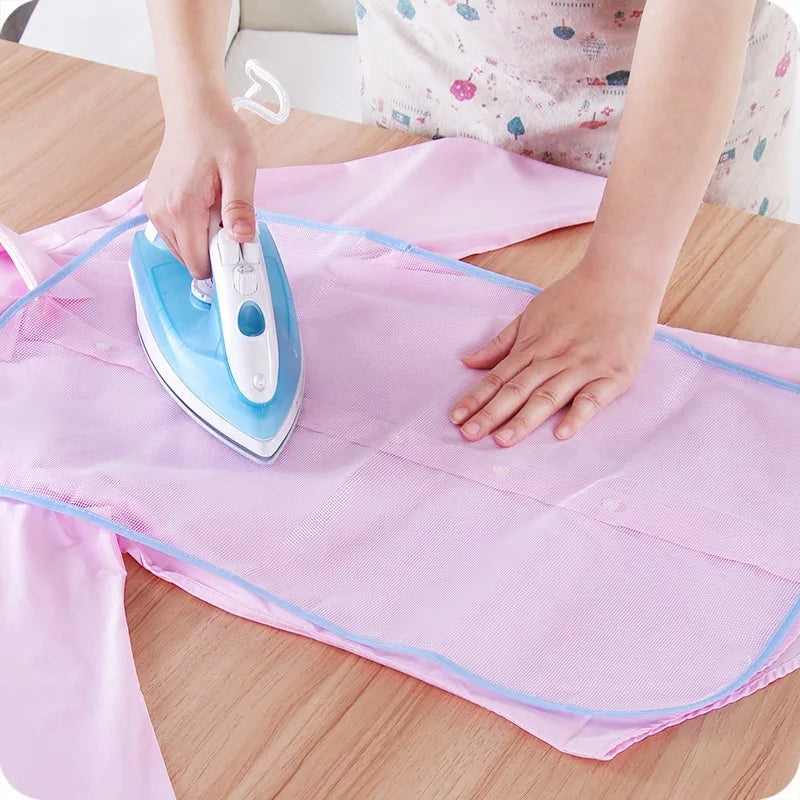 Protective ironing board mat cover, light pink mesh with blue trim and iron in use