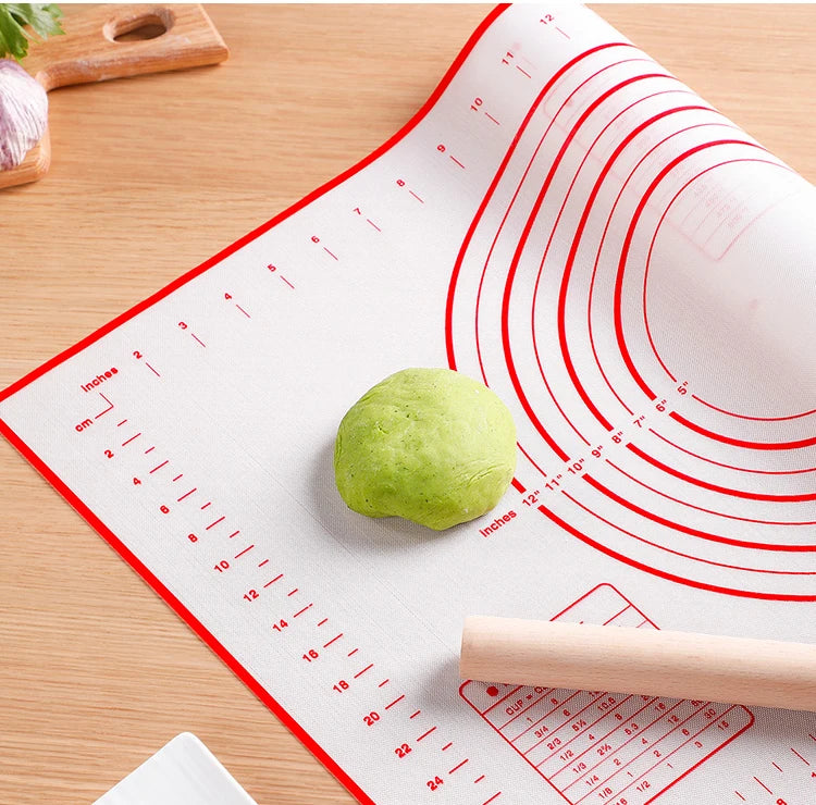 Silicone baking dough mat on countertop with red measurement lines and dough ball