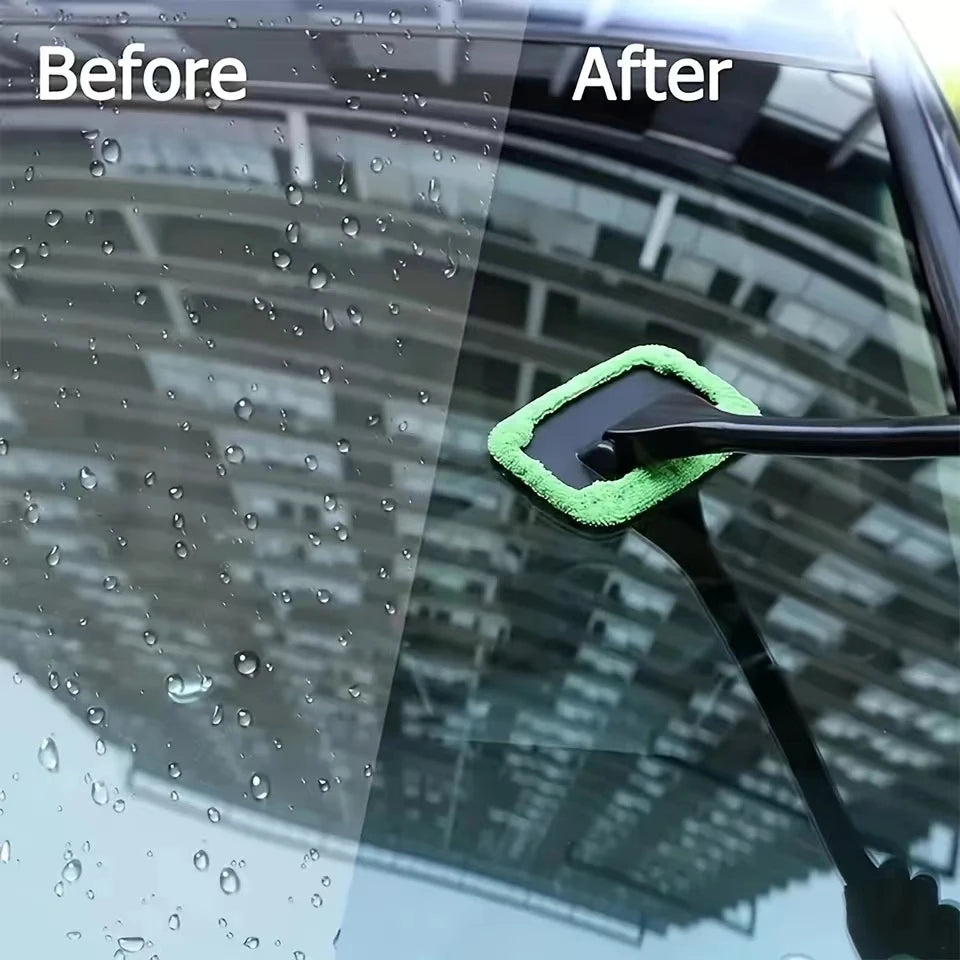 Long-handled windshield cleaning brush with green microfiber pad on auto glass