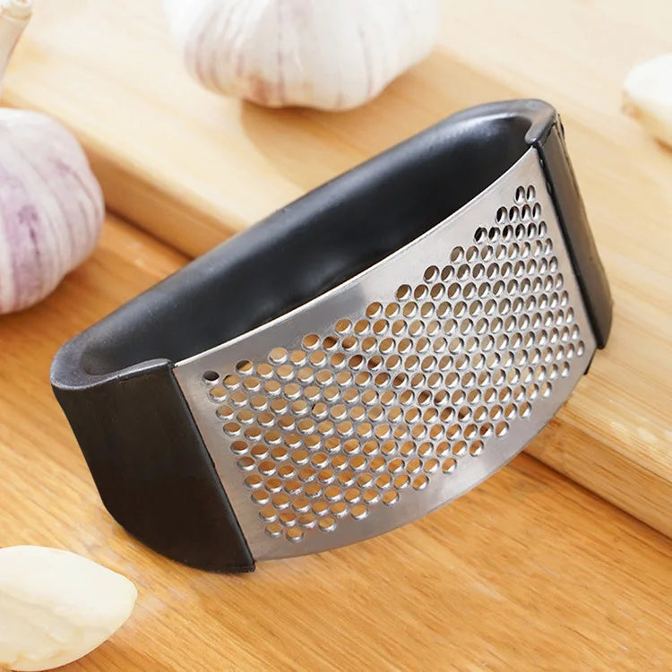 Manual garlic press showing perforated stainless steel grater side view