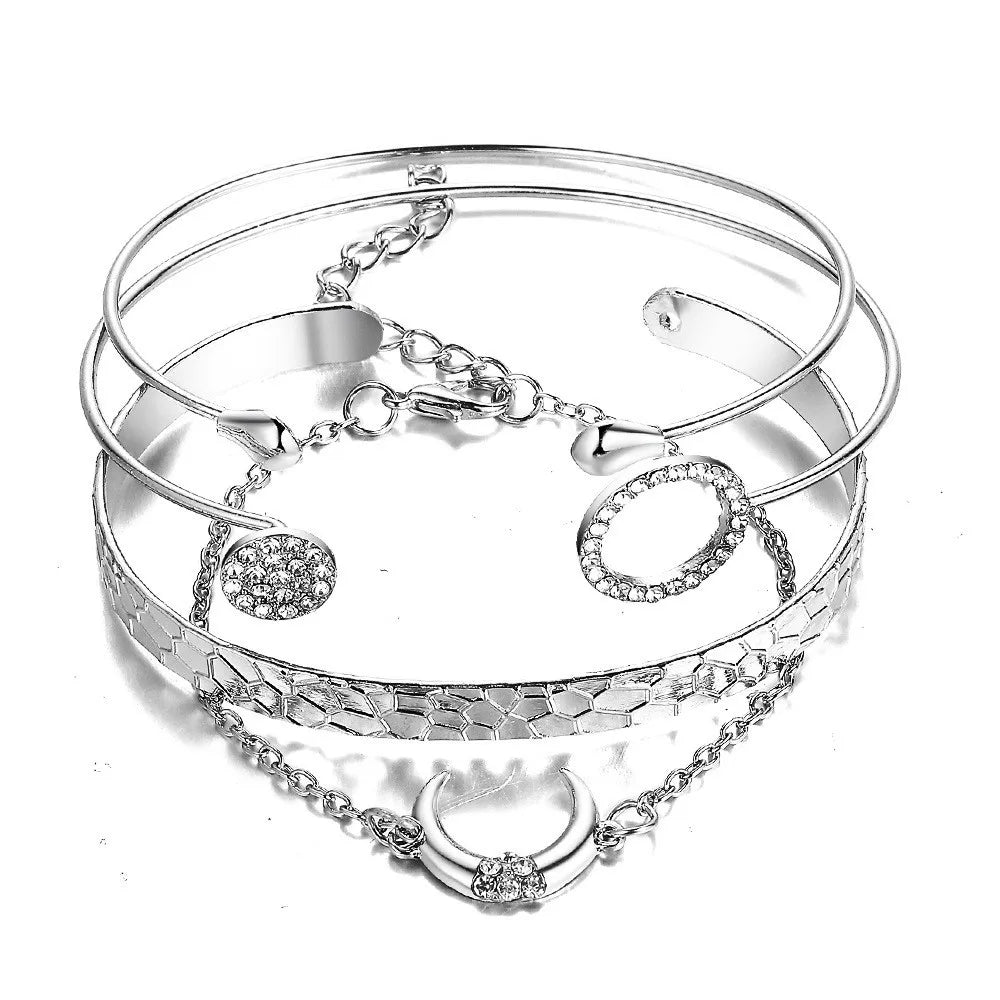 Silver-tone bracelet set with stacked bangles, chain links, and round dangling charms
