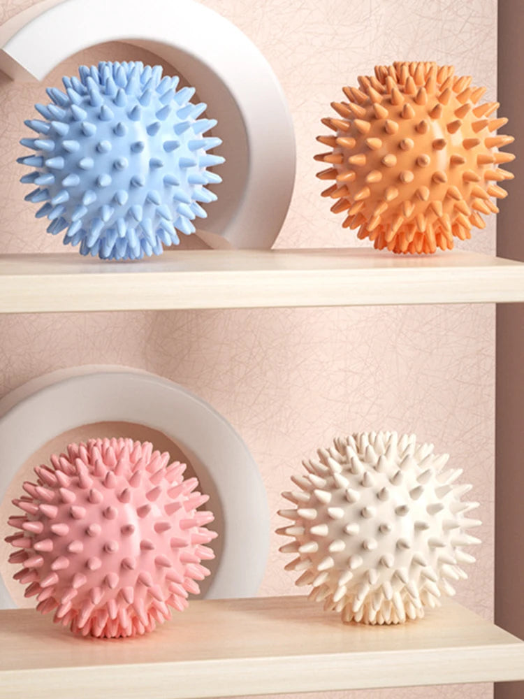 Set of four spiky massage balls: blue, orange, pink, and white