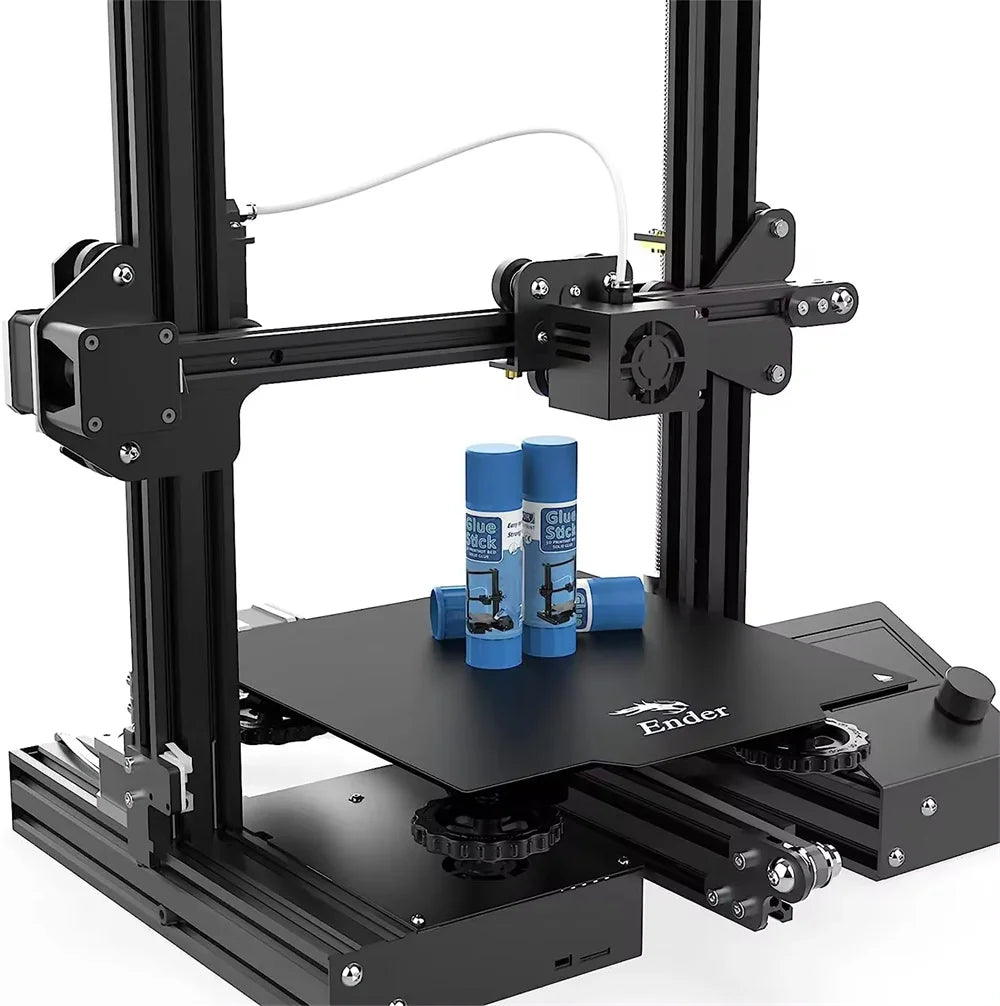 3D printer heated bed with three blue glue stick tubes beside the platform
