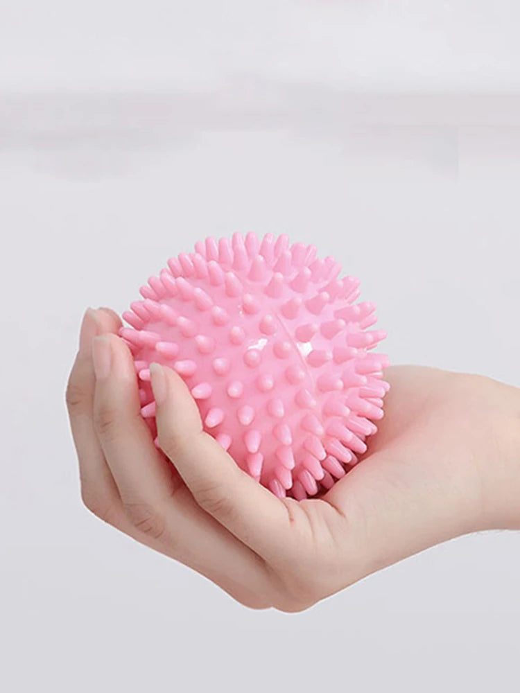 Pink spiky massage ball held in hand