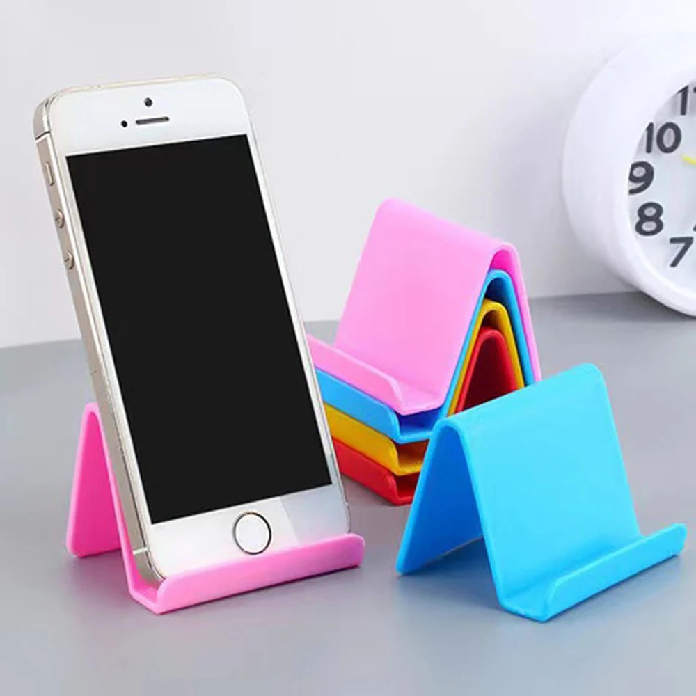 White smartphone on pink plastic phone holder stand with rainbow-colored bases