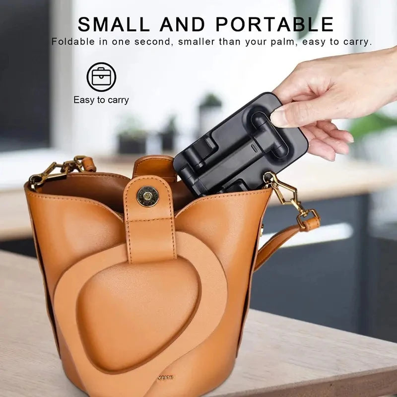 Portable phone holder stand clipped to a tan leather tote bag