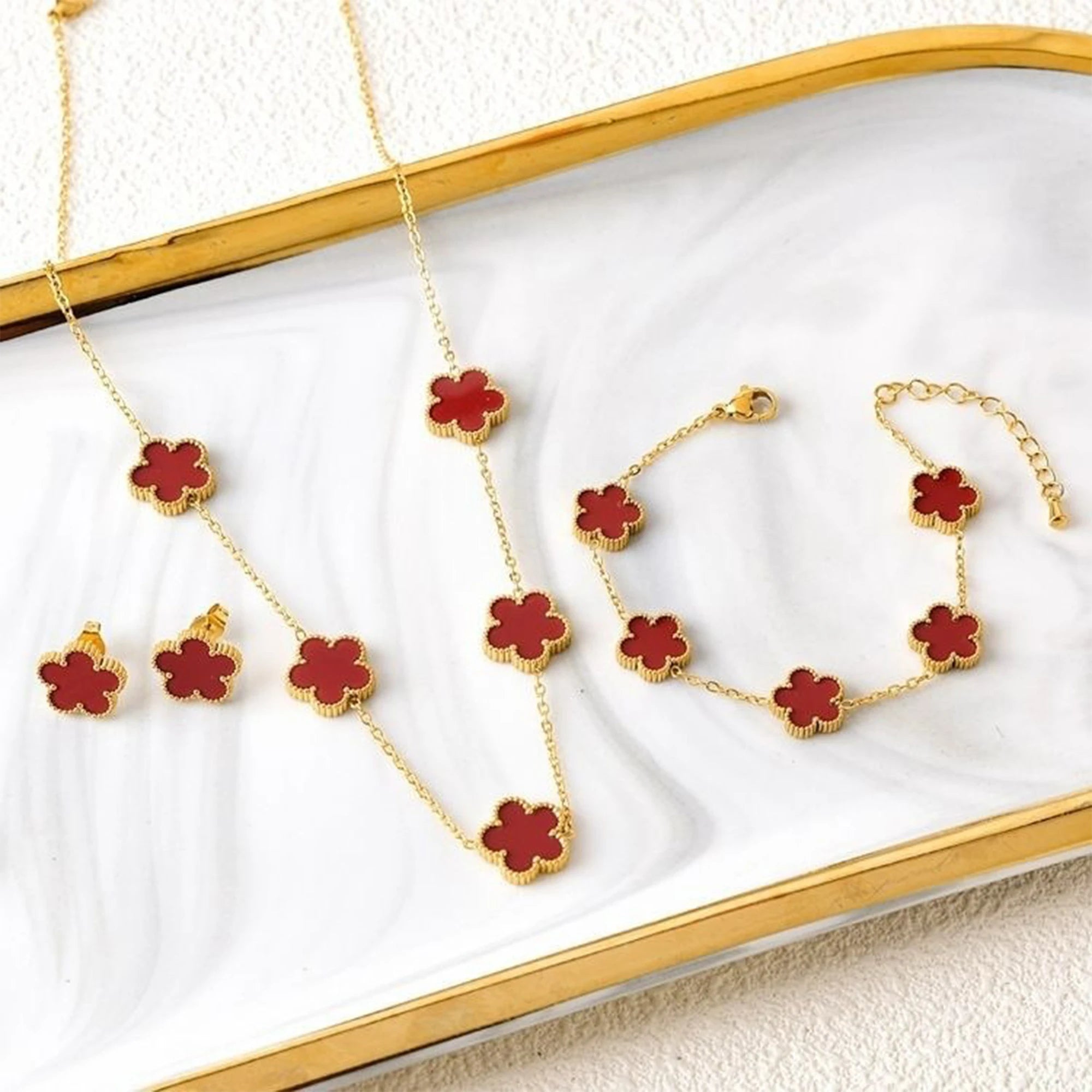 Three-piece clover jewelry set with red enamel five-leaf charms, gold tone necklace and bracelet