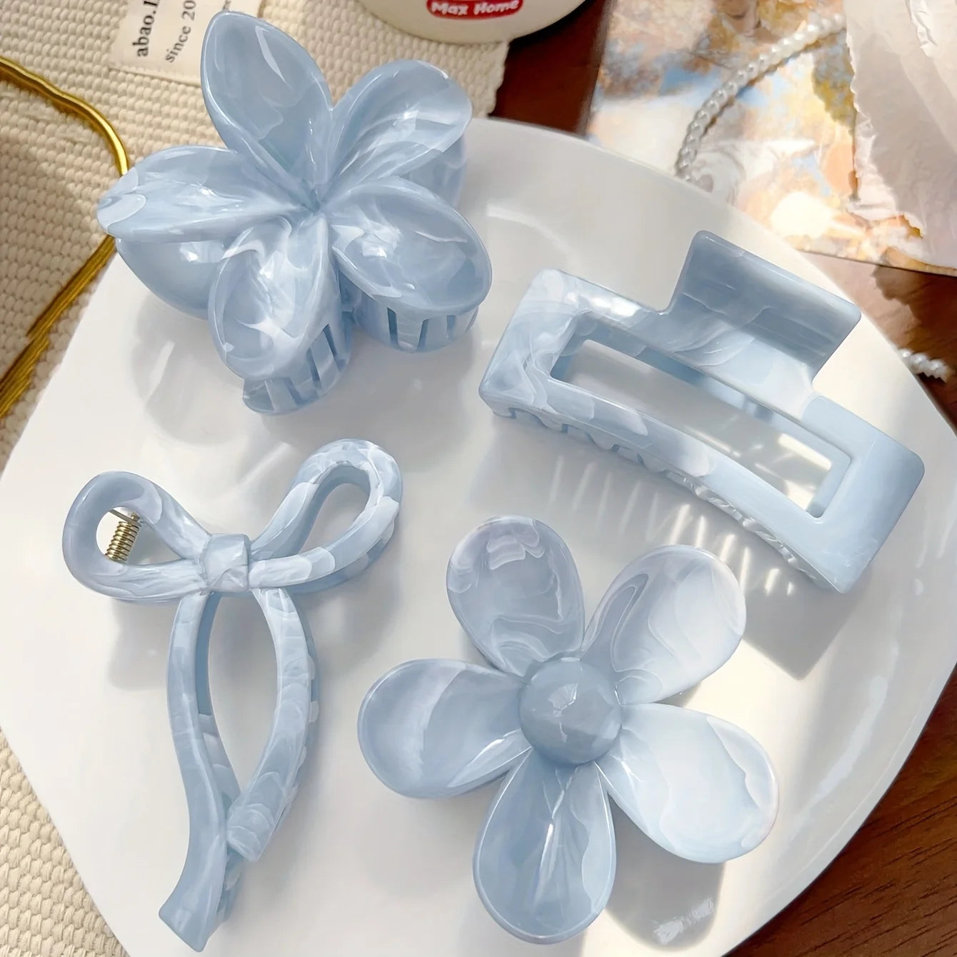 Light blue flower hair claw clip with layered petals and translucent bow accent
