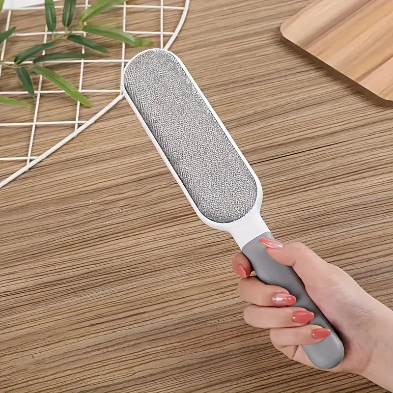 Gray pet hair remover lint brush used on a wooden floor