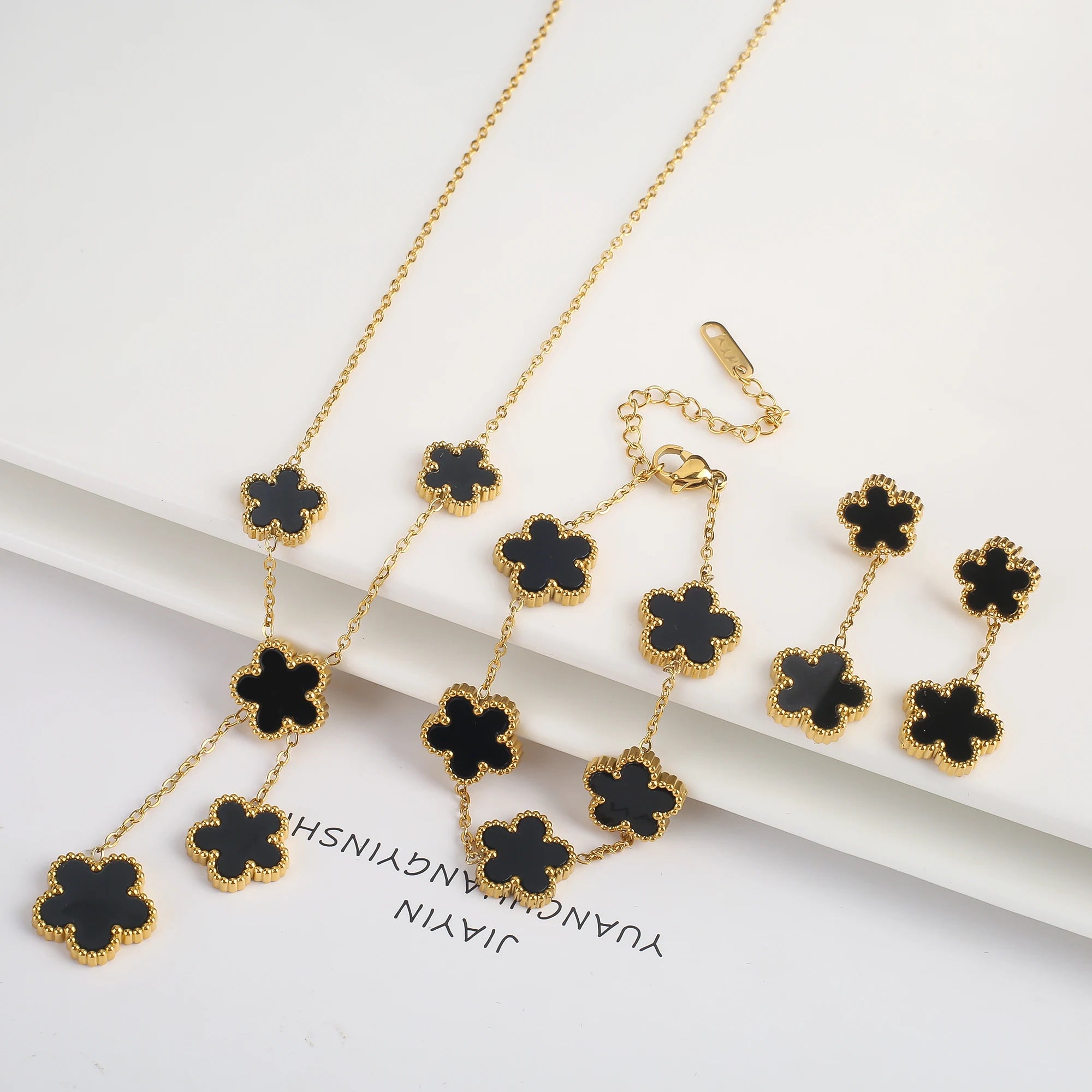 Gold-plated jewelry set with black five-leaf flower necklaces, bracelet, and earrings