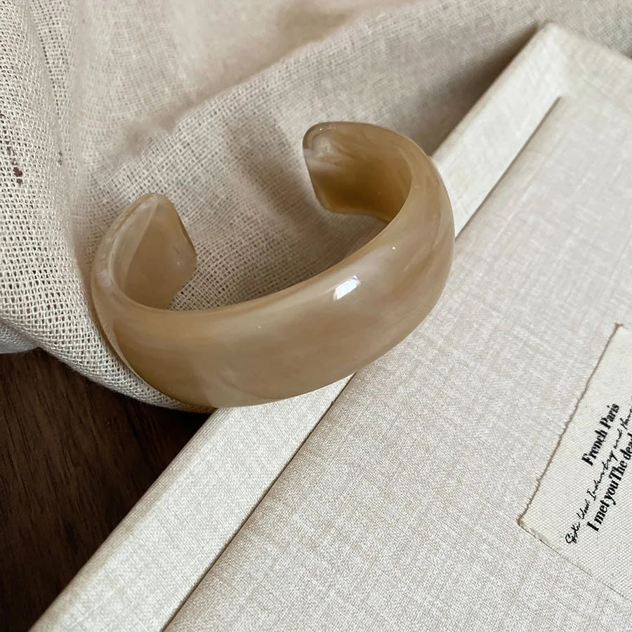 Shiny acrylic open bangle in light beige, wide curved glossy statement bracelet