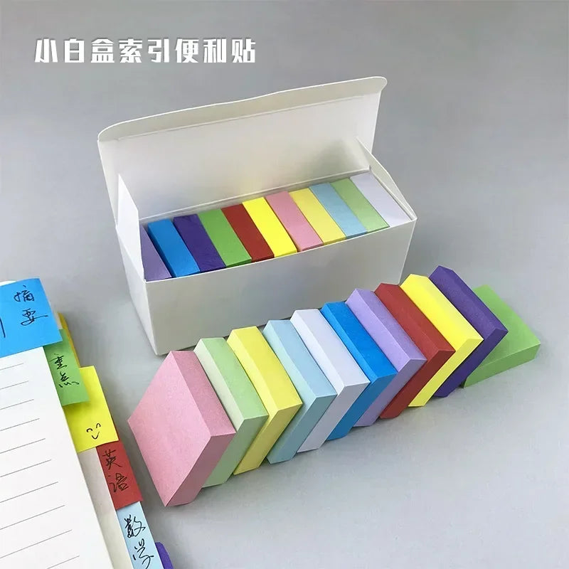 Set of colorful sticky note pads arranged in a white open box