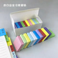 Set of colorful sticky note pads arranged in a white open box