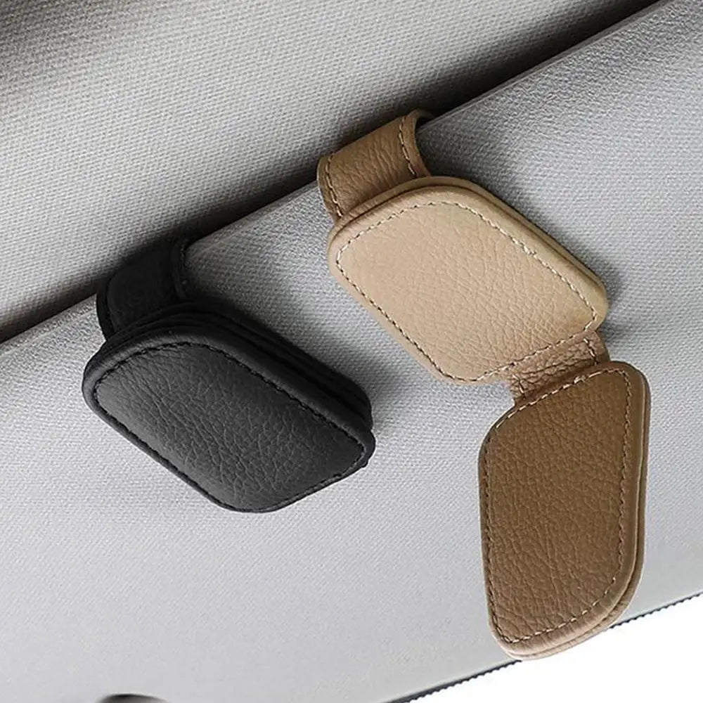 Pair of car glasses clip holders in black and beige with stitched leather-look finish.