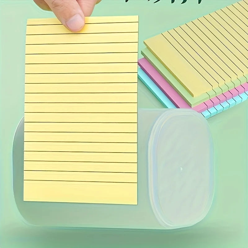 Yellow ruled sticky note pad being picked up, with pastel stacked notes and a clear tray