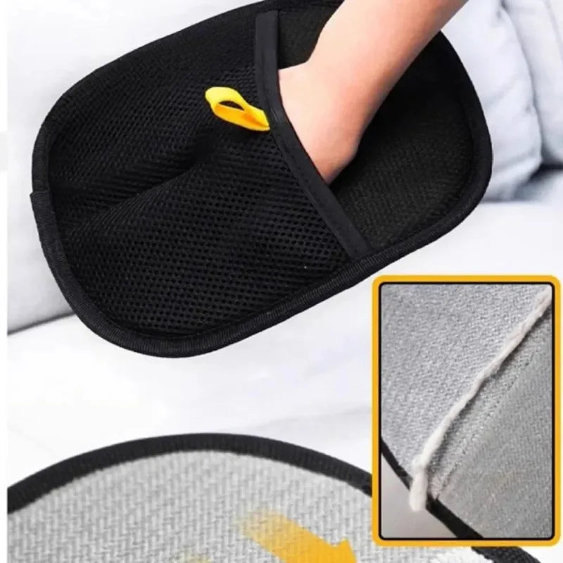 Black pet grooming mitt on hand with mesh texture and yellow tab; gray brush side shown