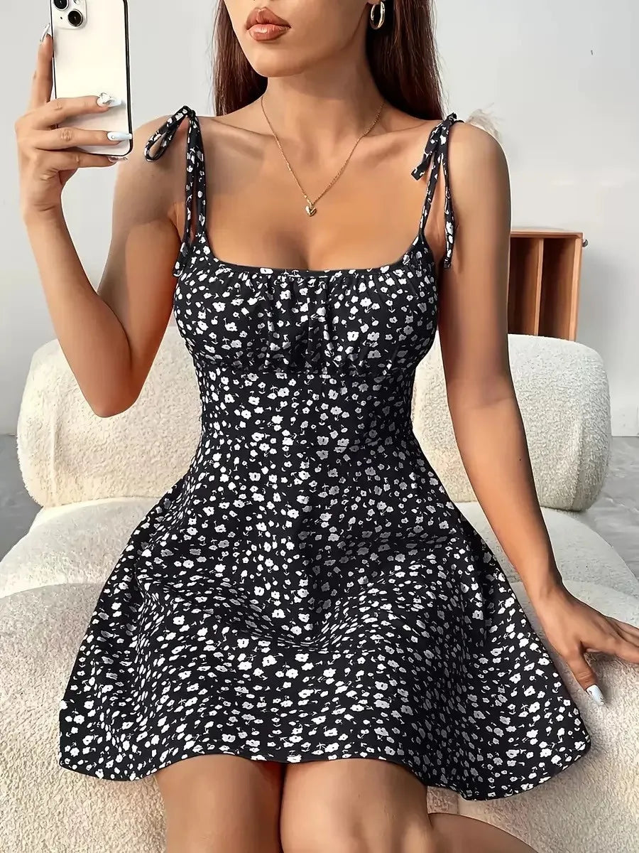 Black floral spaghetti strap short dress with gathered skirt and tie shoulder accents