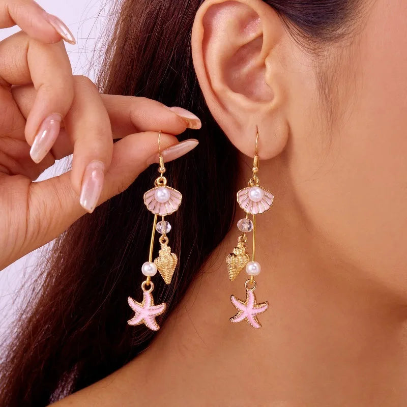 Gold hook earrings with pink shell drops, pearl beads, and starfish dangle charms