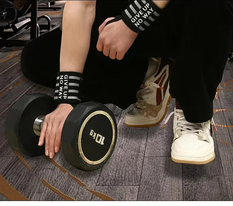 Pair of black-and-white striped wrist wraps worn while lifting a dumbbell