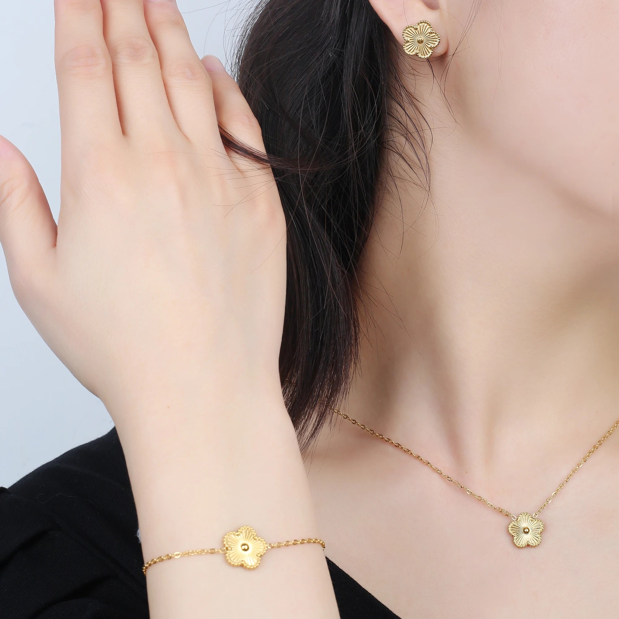 Gold-tone adjustable bracelet featuring small four-leaf clover charms