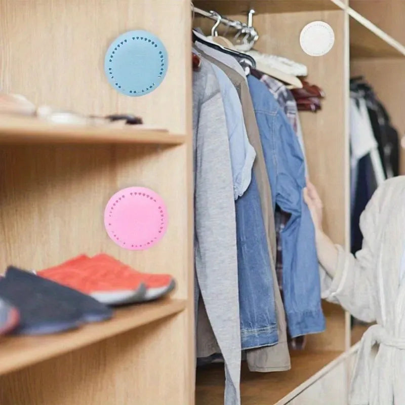 Blue and pink round aromatherapy deodorizing tablets hanging on a wardrobe rail