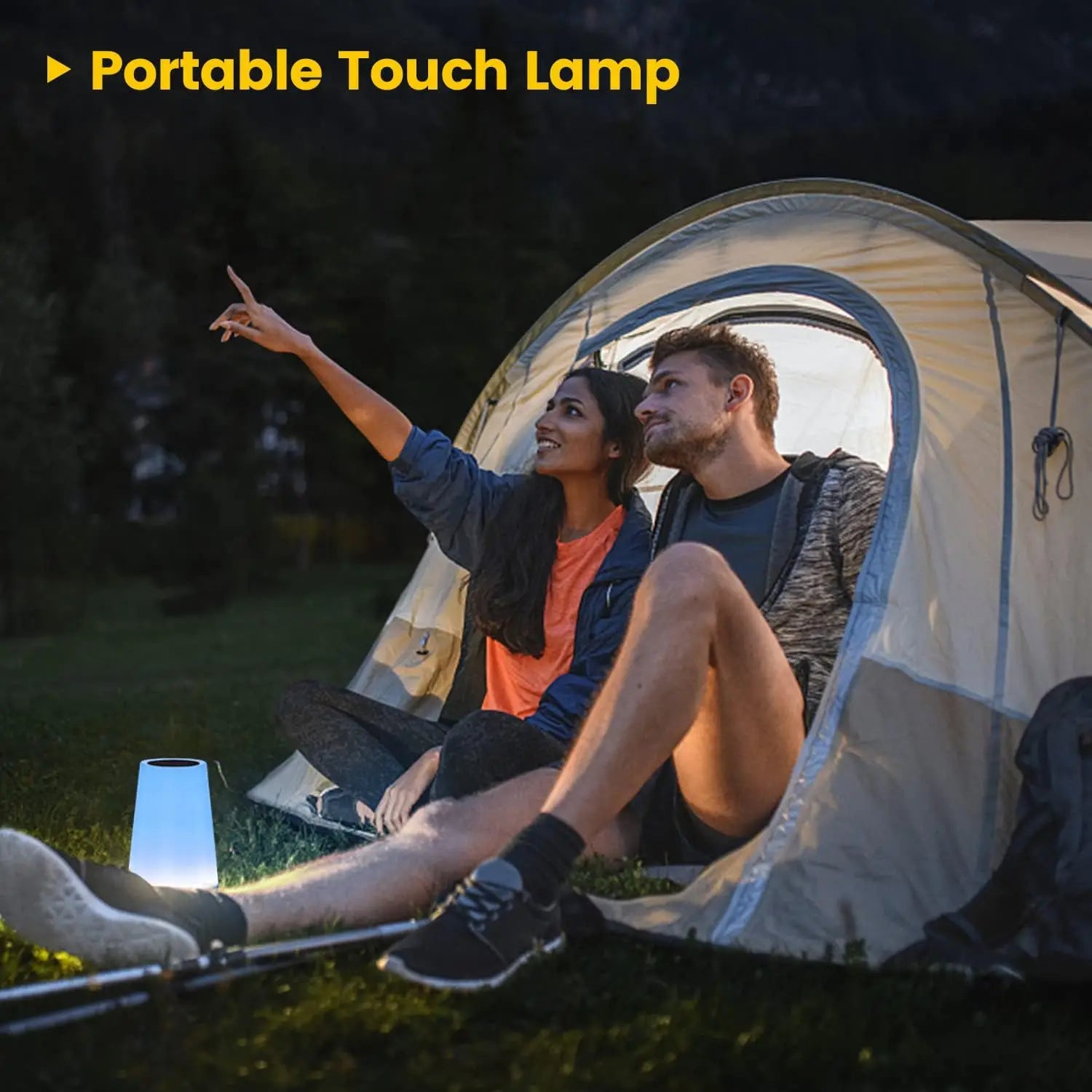 Portable touch lamp glowing on a camping table near a tent.