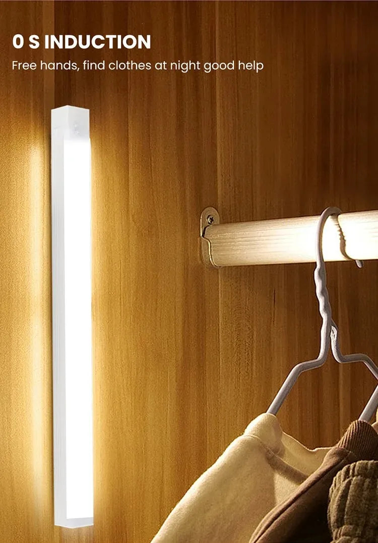 Motion sensor LED strip night light, slim bar glowing beside hanging clothes on a wooden door