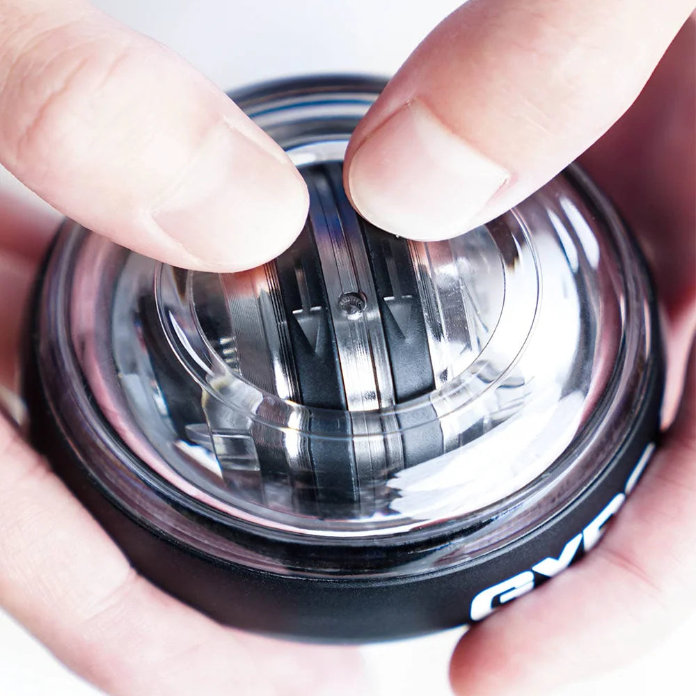 Chrome gyro ball with internal rotor, held between fingers close-up