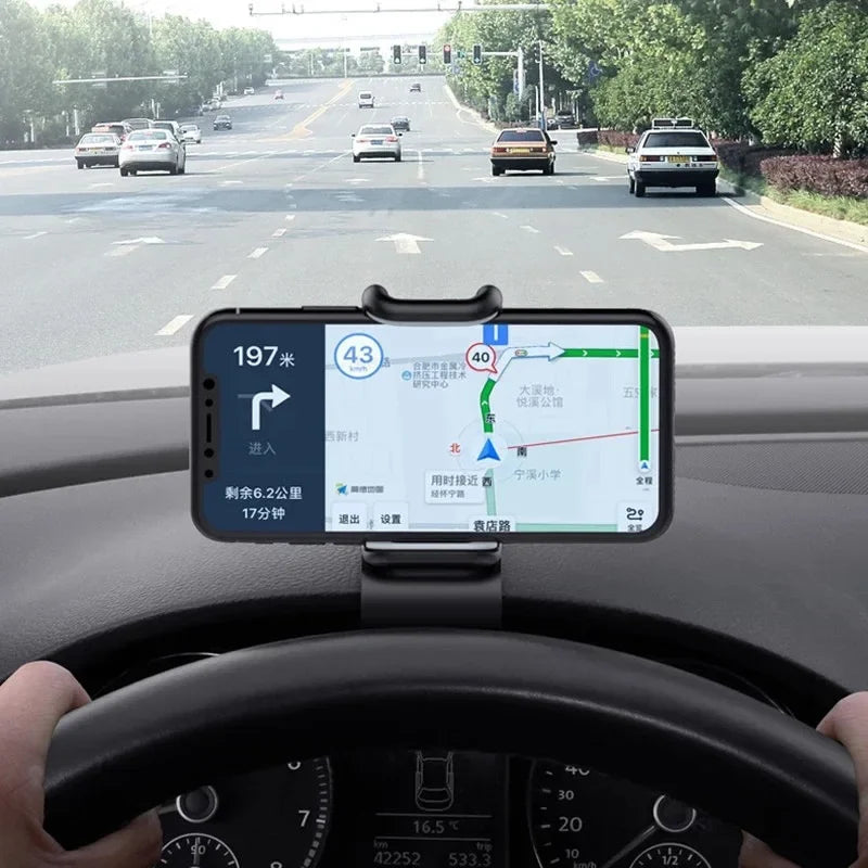 Dashboard-mounted phone holder gripping a smartphone with a clamp base