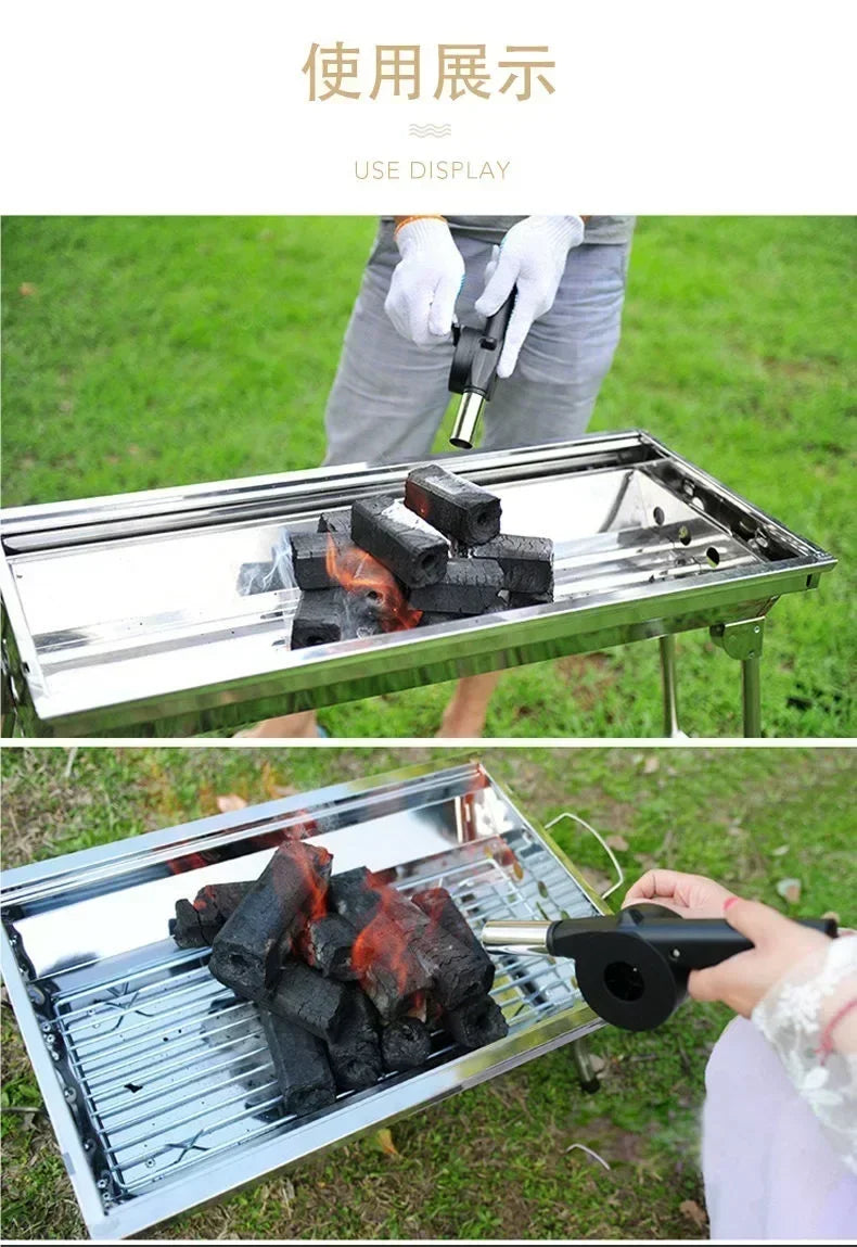 Manual BBQ air blower in use on an outdoor charcoal grill next to burning coals
