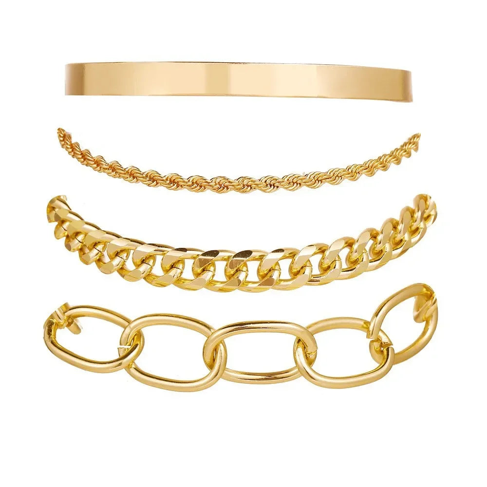 Gold bangle and chain bracelet set with smooth cuff, rope chain, and oval link bangle