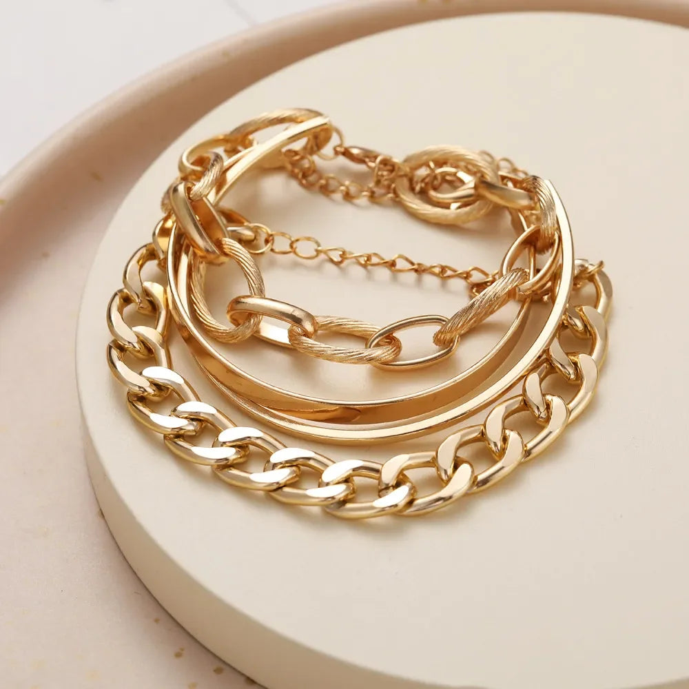 Gold-tone chain bracelet set with layered thick curb links and open bangle cuffs