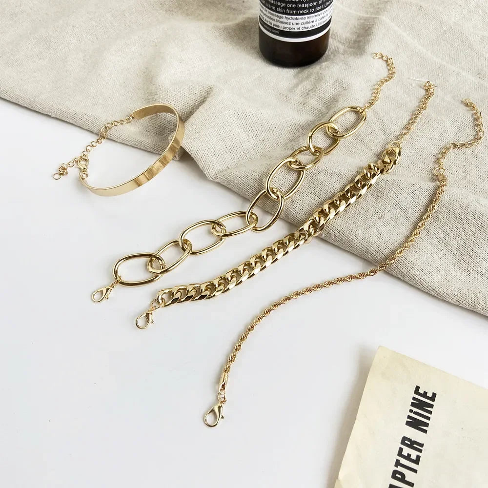 Gold-tone multi-chain bracelet set with open cuffs, layered chains, and heart charm