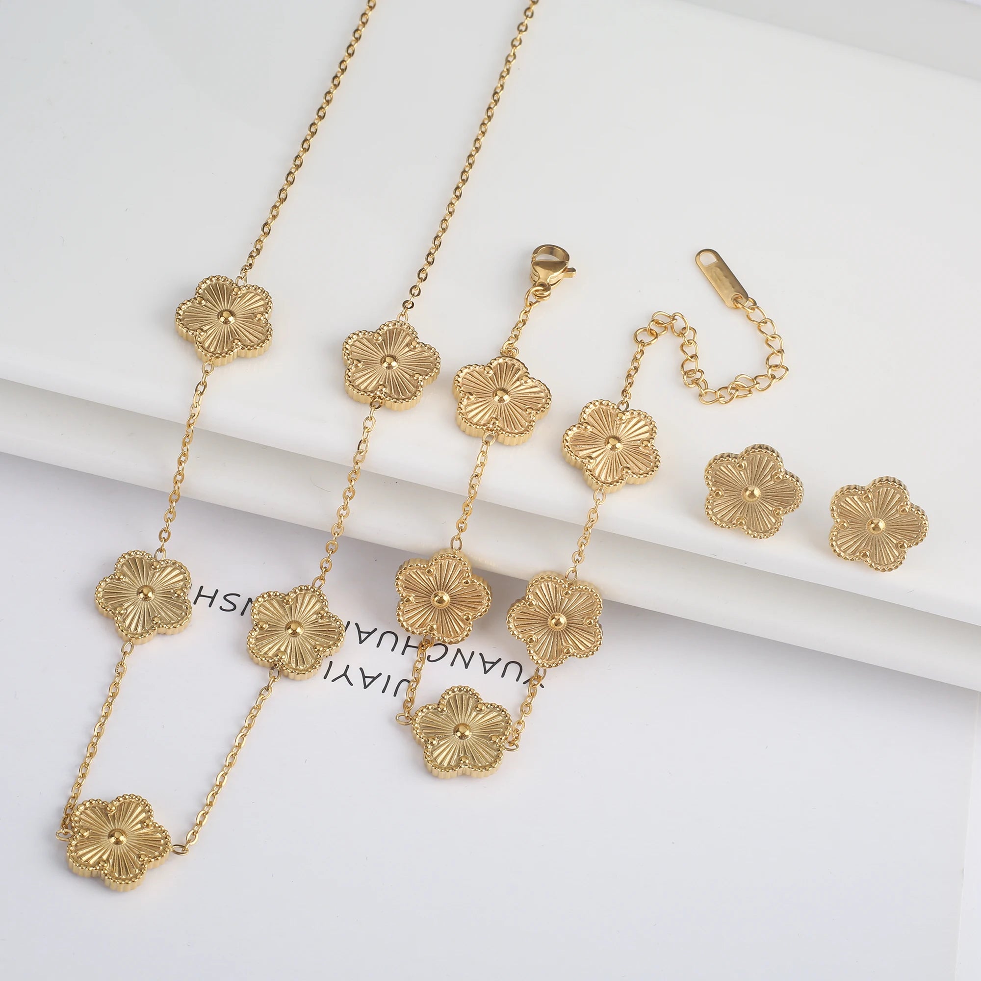 Three-piece clover jewelry set with five-leaf flower charms, gold tone necklaces and stud earrings