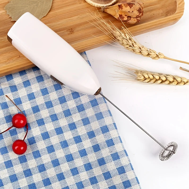 White handheld milk frother with whisk beater, ready for mixing