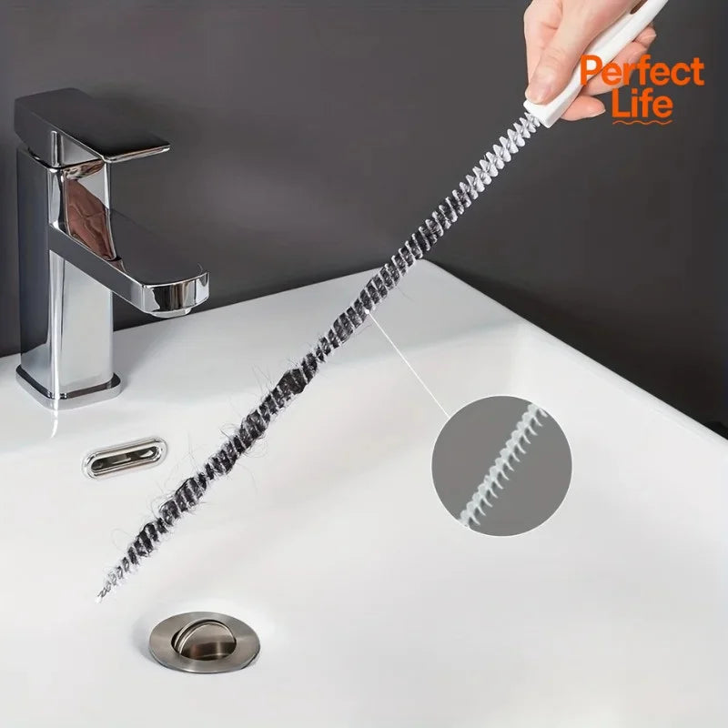 Flexible drain cleaning brush with spiral bristles, white handle, in kitchen sink corner