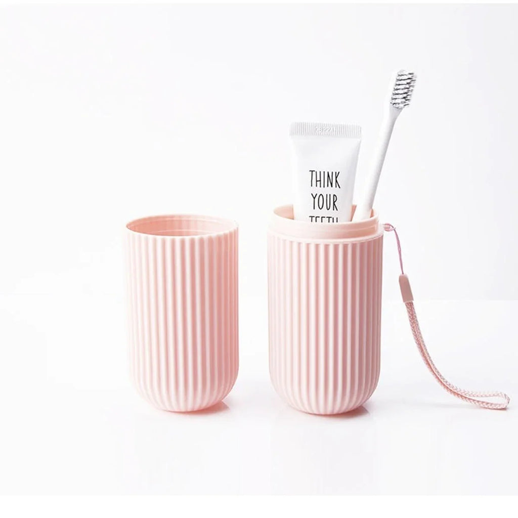 Pink ribbed travel toothbrush holder cup with toothbrush inside