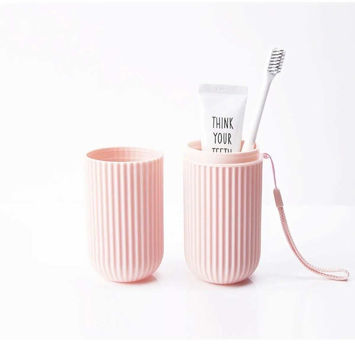 Pink ribbed travel toothbrush holder cup with toothbrush inside
