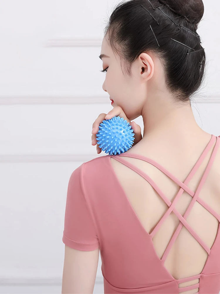 Blue spiky massage ball held against a woman’s shoulder and neck