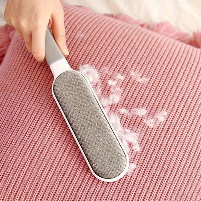 Gray lint brush clearing pet hair from pink knit fabric