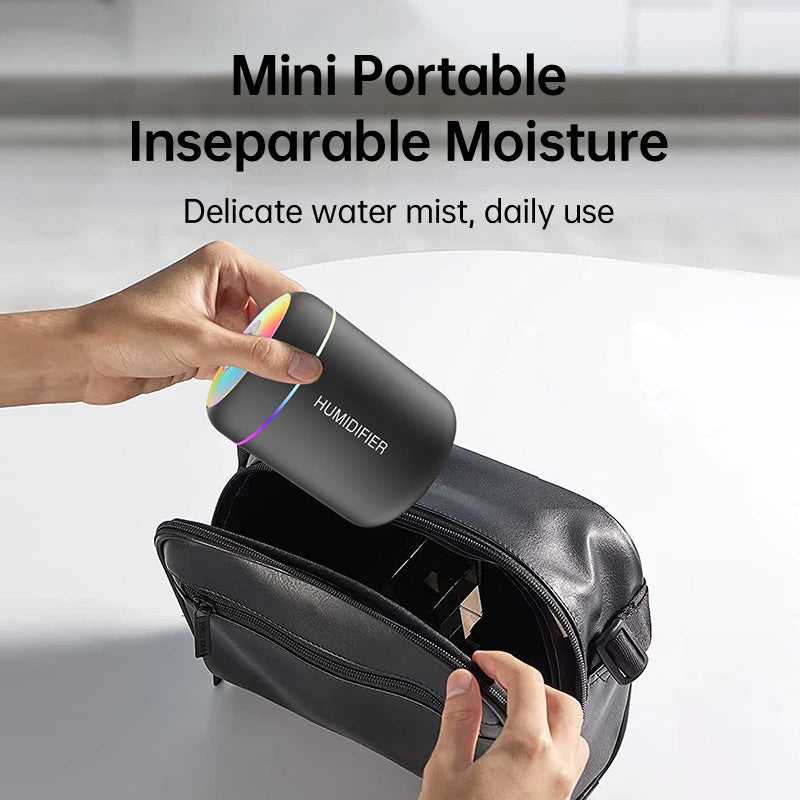 Black mini portable USB humidifier held in hand with rainbow LED top ring